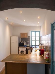 a kitchen with a counter top and a refrigerator at Appartement charmant à Algajola avec terrasse in Algajola