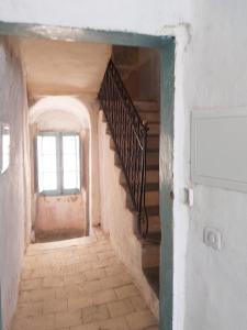 an entrance to a room with a staircase and a window at Appartement charmant à Algajola avec terrasse in Algajola +2 photos