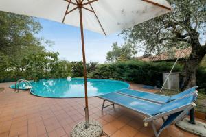 an umbrella and a chair next to a swimming pool at Welcoming Apartment in Fabrica di Roma – 140 sqm, Private Pool in Fabrica di Roma