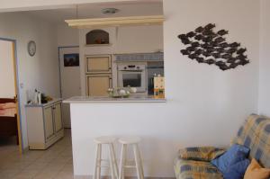 a kitchen and living room with a counter and stools at Appartement cosy à Valras-Plage / 48m² / Piscine partagée in Valras-Plage