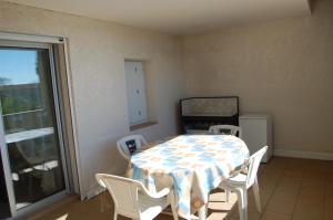 a dining room with a table and chairs and a window at Appartement cosy à Valras-Plage / 48m² / Piscine partagée in Valras-Plage