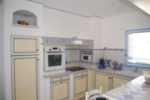 a kitchen with a stove and a microwave at Appartement cosy à Valras-Plage / 48m² / Piscine partagée in Valras-Plage +9 photos