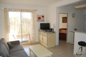 a living room with a couch and a tv at Appartement cosy à Valras-Plage / 48m² / Piscine partagée in Valras-Plage