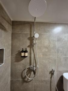 a shower in a bathroom with a shower head at Snuggy Hostel Kuta in Kuta Lombok +24 photos