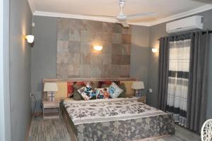 a bedroom with a bed and a stone wall at Charming Studio in Blue Bay, 22 m², Near Beaches in Blue Bay