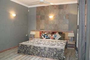 a bedroom with a bed and two lamps and a wall at Charming Studio in Blue Bay, 22 m², Near Beaches in Blue Bay