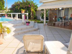 a chair sitting on a patio next to a pool at Studio cosy aux Abymes, piscine et jardin, 25 m² in Les Abymes
