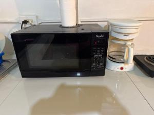 a microwave sitting on top of a kitchen counter at MaFlo Arms in Belize City
