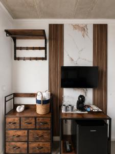 a room with a dresser and a desk with a television at Alta Vista Apollonia Sunset in Sozopol