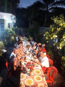 a group of people sitting at a long long table at Charming Apartment in Pereybere with Shared Pool, 75 m² in Pereybere