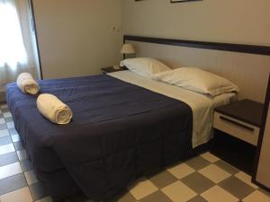 a bedroom with a large bed with towels on it at Hotel Eva in Milan