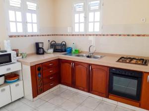 a kitchen with a sink and a stove top oven at Appartement spacieux au Vauclin de 150 m² avec vue montagne in Le Vauclin +11 photos