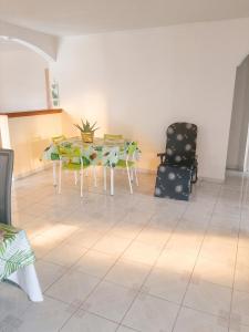 a dining room with a table and a chair at Appartement spacieux au Vauclin de 150 m² avec vue montagne in Le Vauclin