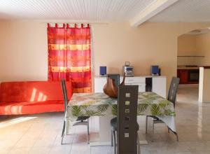 a living room with a table and a couch at Appartement spacieux au Vauclin de 150 m² avec vue montagne in Le Vauclin