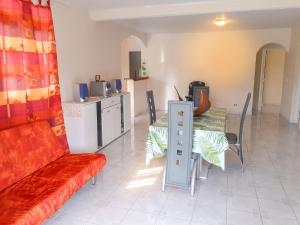 a living room with a couch and a table and chairs at Appartement spacieux au Vauclin de 150 m² avec vue montagne in Le Vauclin
