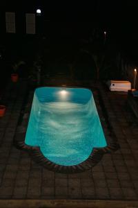 a blue swimming pool in the middle of a yard at night at Luxurious Villa in Pereybere with Pool in Pereybere