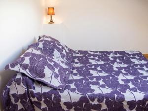 a bed with a purple and white pillow and a lamp at Maison charmante avec vue sur lac à Thil-sur-Arroux in Thil-sur-Arroux