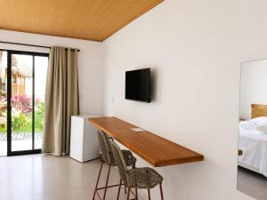 a room with a desk and two chairs and a bed at Lighthouse Pipa in Tibau do Sul