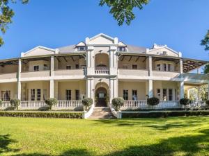 an exterior view of a large white house with a lawn at Kearsney Manor in KwaDukuza