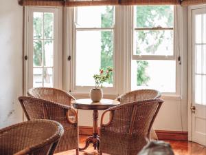 a room with chairs and a table and windows at Kearsney Manor in KwaDukuza