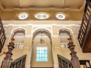 an ornate staircase in a building with stained glass windows at Kearsney Manor in KwaDukuza