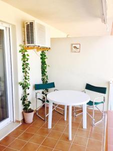 a white table and chairs in a room with plants at Cozy apartment in Dénia, 40 m² with shared pool in Denia