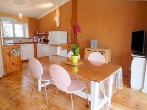 a kitchen with a wooden table and chairs in a room at Maison cosy avec piscine privée à Estibeaux 38 m² in Estibeaux