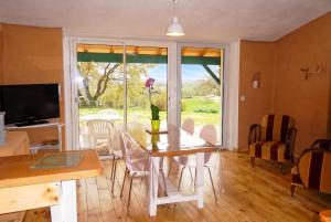 a dining room with a table and chairs and a window at Maison cosy avec piscine privée à Estibeaux 38 m² in Estibeaux