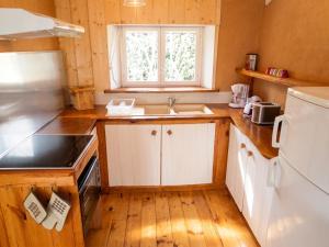 a kitchen with white cabinets and a sink and a window at Maison cosy avec piscine privée à Estibeaux 38 m² in Estibeaux