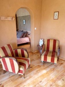 a living room with two chairs and a bed at Maison cosy avec piscine privée à Estibeaux 38 m² in Estibeaux +10 photos