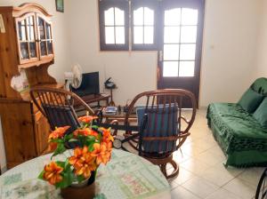 a living room with a table and chairs and a couch at Appartement spacieux à Petit Canal - 65 m² - Vue sur jardin in Petit-Canal