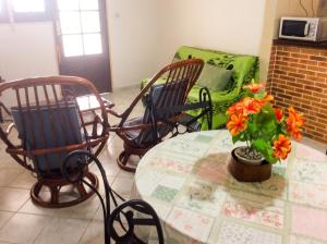 a room with three chairs and a table and a couch at Appartement spacieux à Petit Canal - 65 m² - Vue sur jardin in Petit-Canal +7 photos