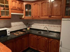 a kitchen with wooden cabinets and a sink at Cozy apartment with sea view in Frontera in Frontera