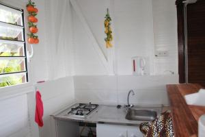 a small kitchen with a stove and a sink at Bungalow charmant à Rivière-Salée avec terrasse privée in Rivière-Salée