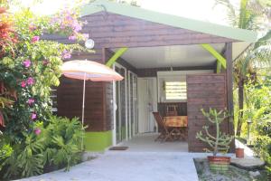 a small shed with an umbrella and a table at Bungalow charmant à Rivière-Salée avec terrasse privée in Rivière-Salée
