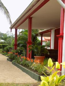 a house with red columns and plants in the yard at Charming house with sea view in Foulpointe + Enclosed garden. in Foulpointe