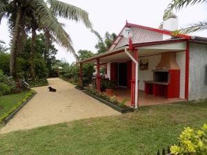 a cat sitting in front of a house at Charming house with sea view in Foulpointe + Enclosed garden. in Foulpointe
