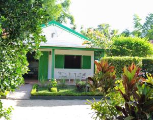 a green and white house with a table and chairs at Charming house with sea view in Foulpointe + Enclosed garden. in Foulpointe