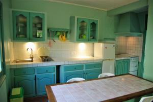 a kitchen with blue cabinets and a table in it at Charming house with sea view in Foulpointe + Enclosed garden. in Foulpointe +18 photos