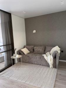 a living room with a gray couch and a table at Millennium Apart Complex in Sveti Vlas