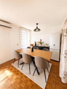 a dining room with a wooden table and chairs at Riverside Apartment, 10min Airport in Sarajevo +8 photos