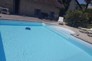 a large blue swimming pool with a swing at Villa spacieuse avec piscine à Aspin-en-Lavedan, vue montagne. in Aspin-en-Lavedan +18 photos