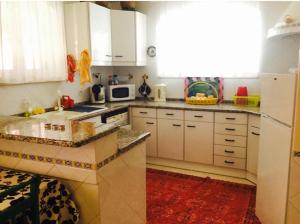 a kitchen with white cabinets and a red rug at Spacious Apartment Sintra 120 m² + Pool in Sintra