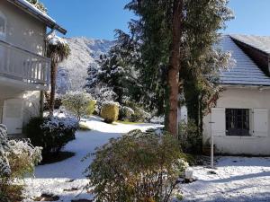 a snow covered yard with a house and trees at Villa spacieuse avec piscine à Aspin-en-Lavedan, vue montagne. in Aspin-en-Lavedan