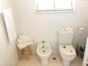 a white bathroom with a toilet and a sink at Spacious Apartment Sintra 120 m² + Pool in Sintra