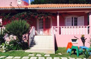 a pink house with stairs and chairs in the yard at Spacious Apartment Sintra 120 m² + Pool in Sintra +5 photos