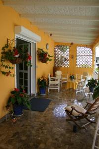 a living room with chairs and a table and plants at Villa élégante à Sainte-Anne avec piscine privée ouverte toute l'année in Sainte-Anne