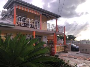 a house with a balcony and a car at Appartement Moderne à Capesterre de Marie Galante avec Balcon in Vidon