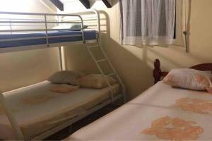 a bedroom with two bunk beds and a window at Appartement Moderne à Capesterre de Marie Galante avec Balcon in Vidon