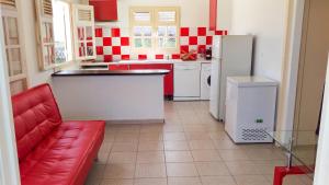 a kitchen with a red couch and a refrigerator at Maison accueillante à Anse-Bertrand avec jardin privé 70 m² in Anse-Bertrand